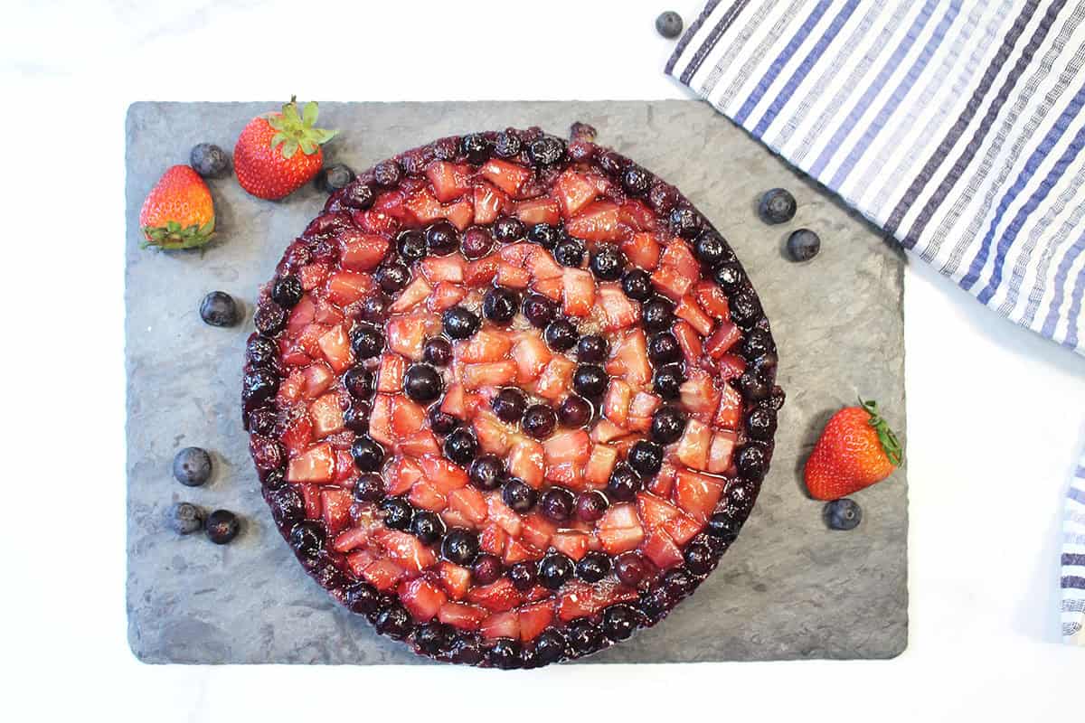 Cake turned out of pan with fruit on top.