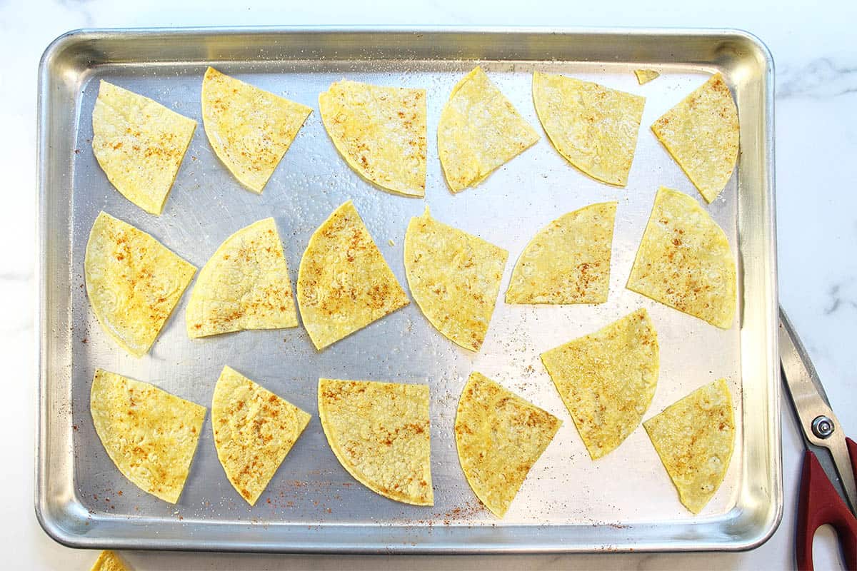 Cut tortilla pieces laid out on cookie sheet and ready to bake.