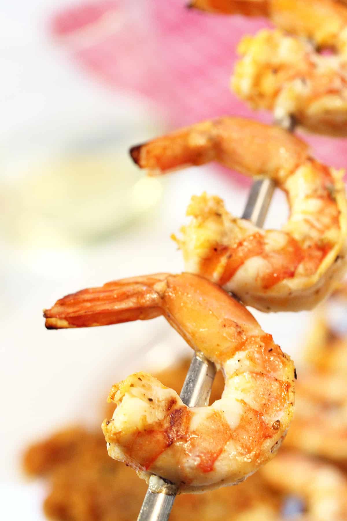 Closeup of shrimp on skewer over plated dinner