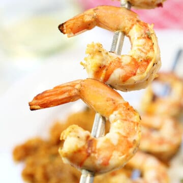 Closeup of a few grilled shrimp on skewer.