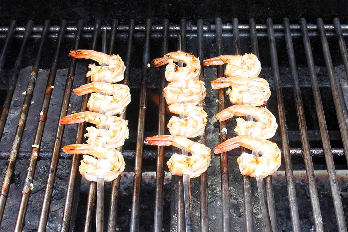 Grilling shrimp skewers on grill.