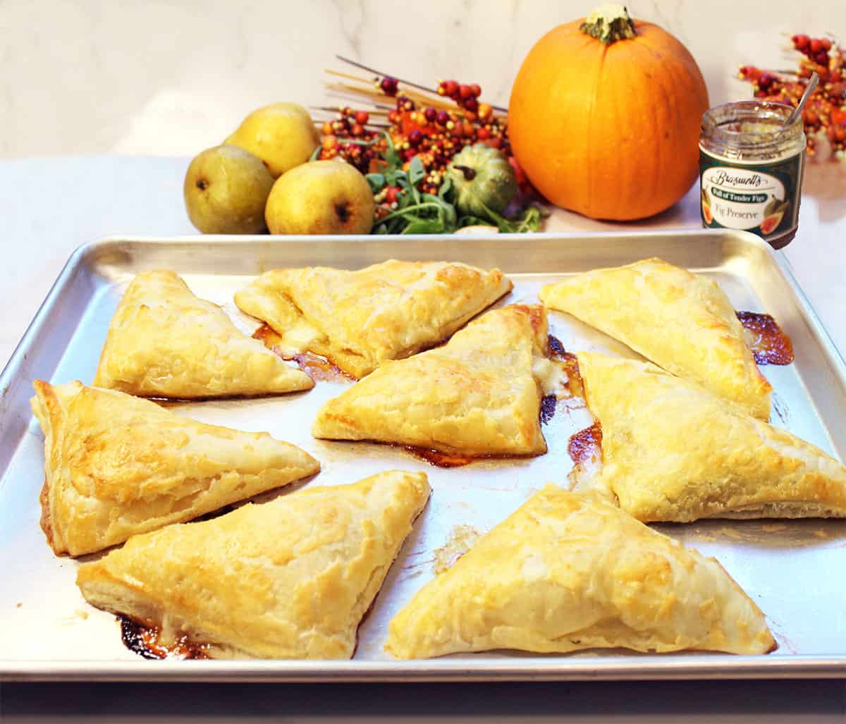 Baked pear ham and cheese pockets on cookie sheet.