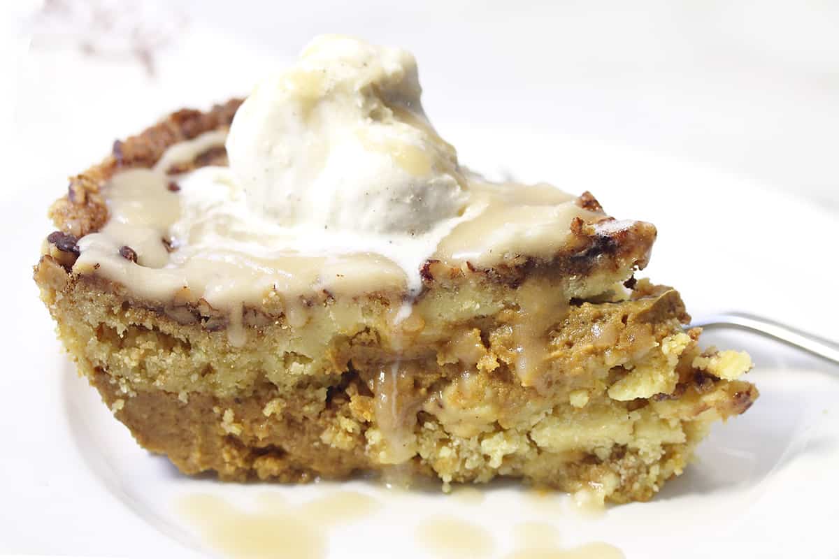 Closeup slice of Skillet Pumpkin Dump Cake on white plate showing layers.