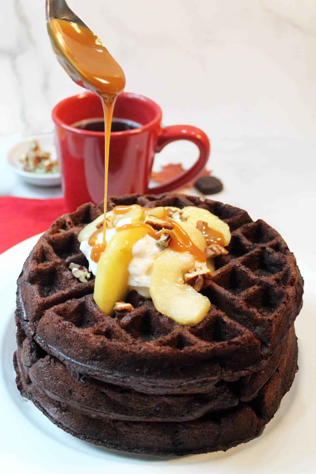 https://2cookinmamas.com/wp-content/uploads/2020/10/Drizzling-caramel-sauce-over-waffles-tall-closeup.jpg