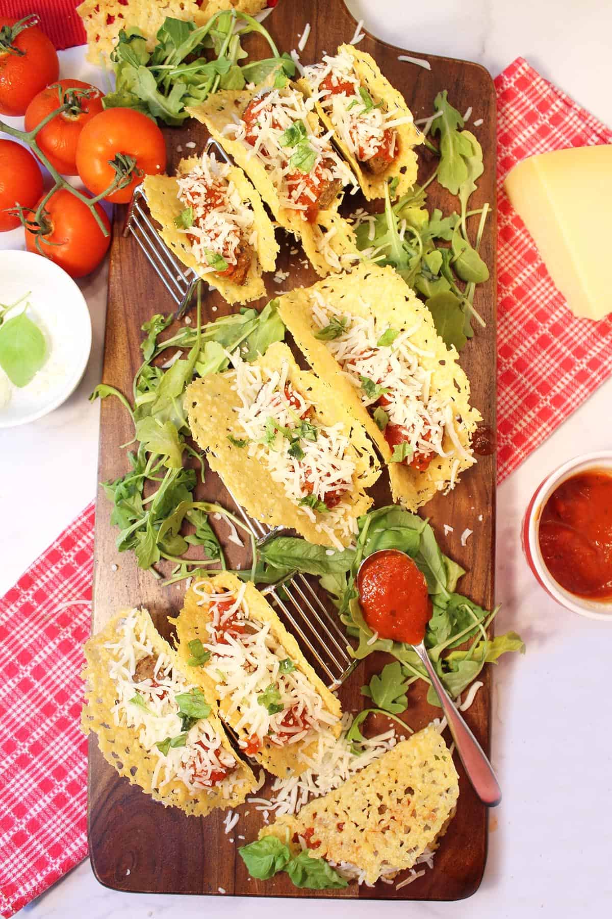 Overhead of taco serving platter with spoonful of sauce on board.