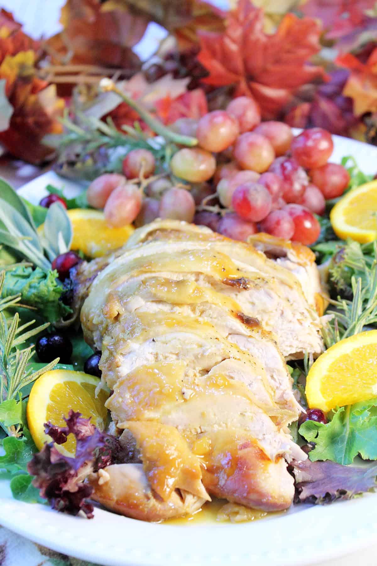 Honey Baked Turkey Breast sliced turkey on fruit decorated platter.