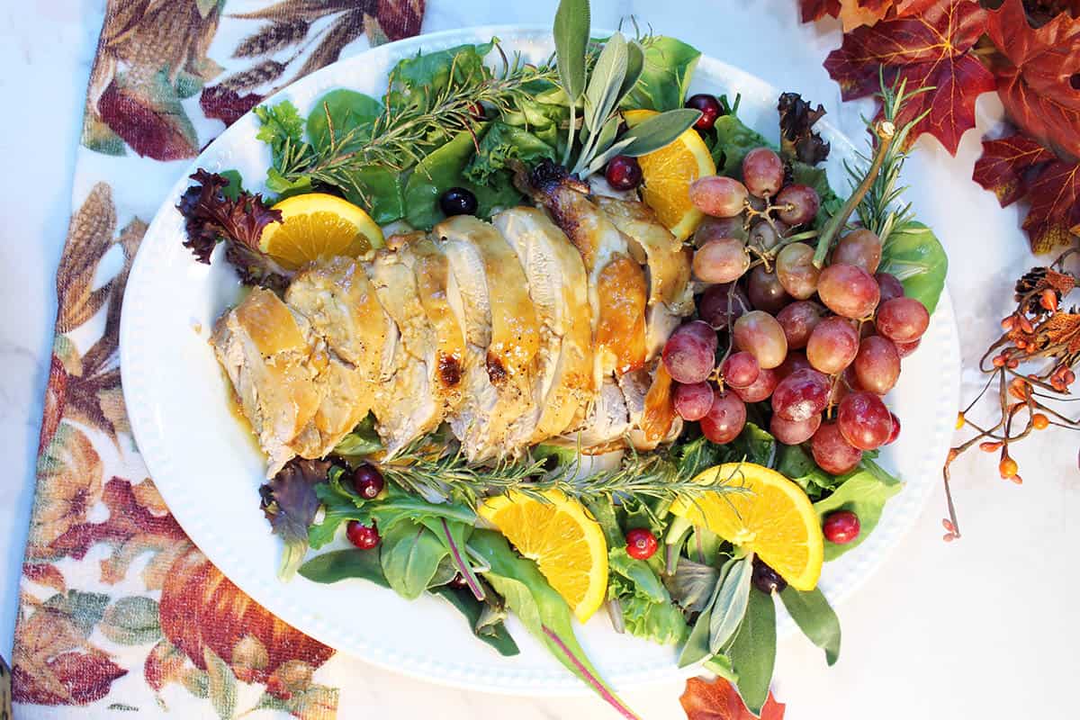 Platter of sliced turkey breast with garnishes.