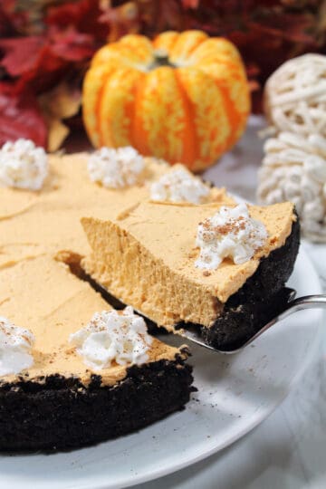 Lifting slice of No Bake Pumpkin Cheesecake.