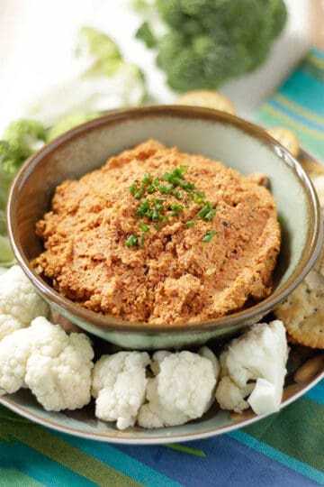 Roasted Red Pepper Dip in bowl with dippers around it.