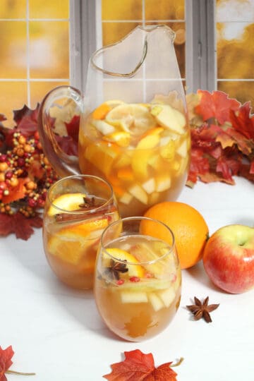Apple Cider Sangria pitcher with filled glasses.