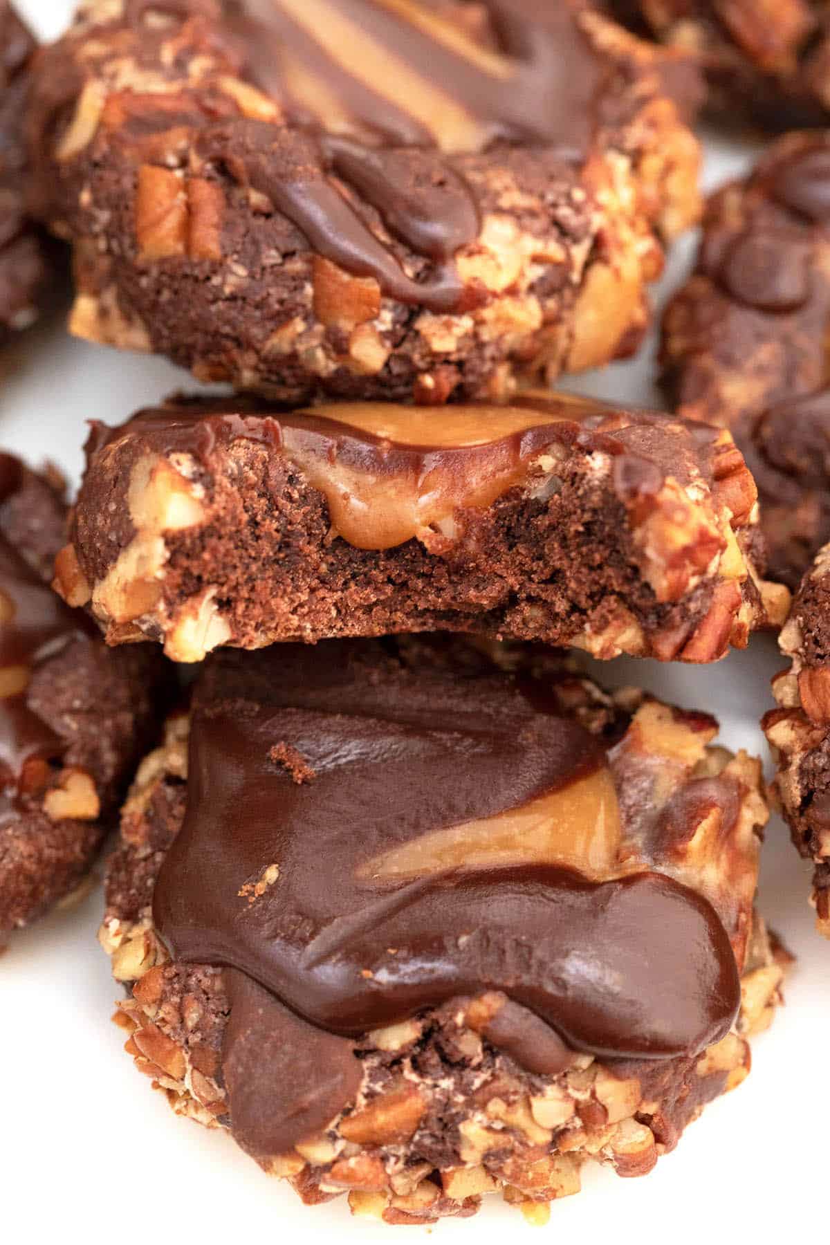 Stacked turtle cookies showing chocolate drizzle.