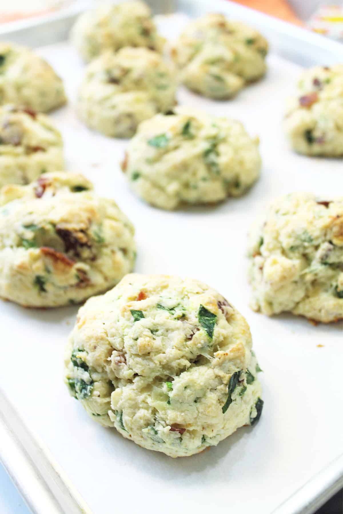 Baked cheese and bacon scones on parchment lined cookie sheet.