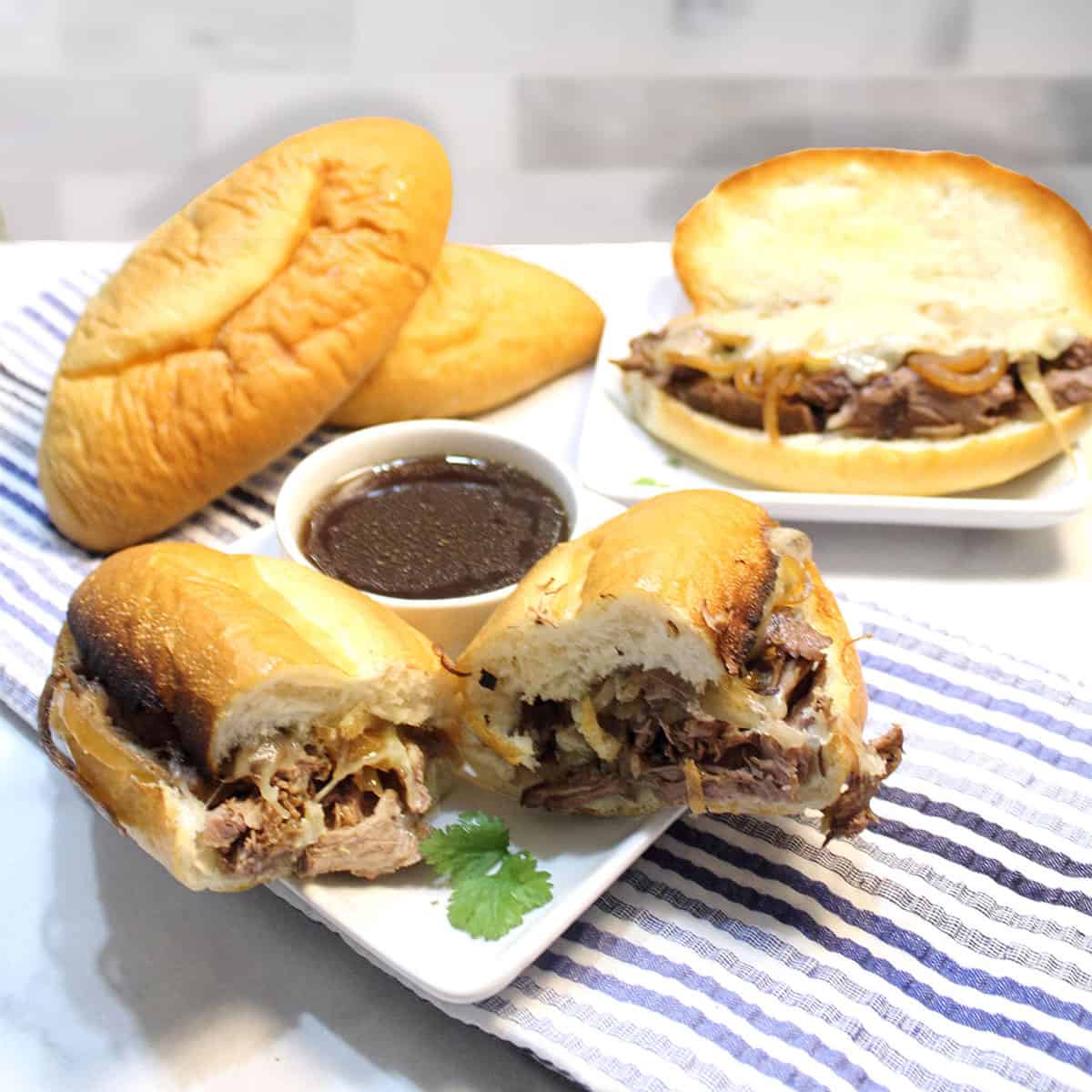 Crockpot French Dip Sandwiches on white plate with au jus.