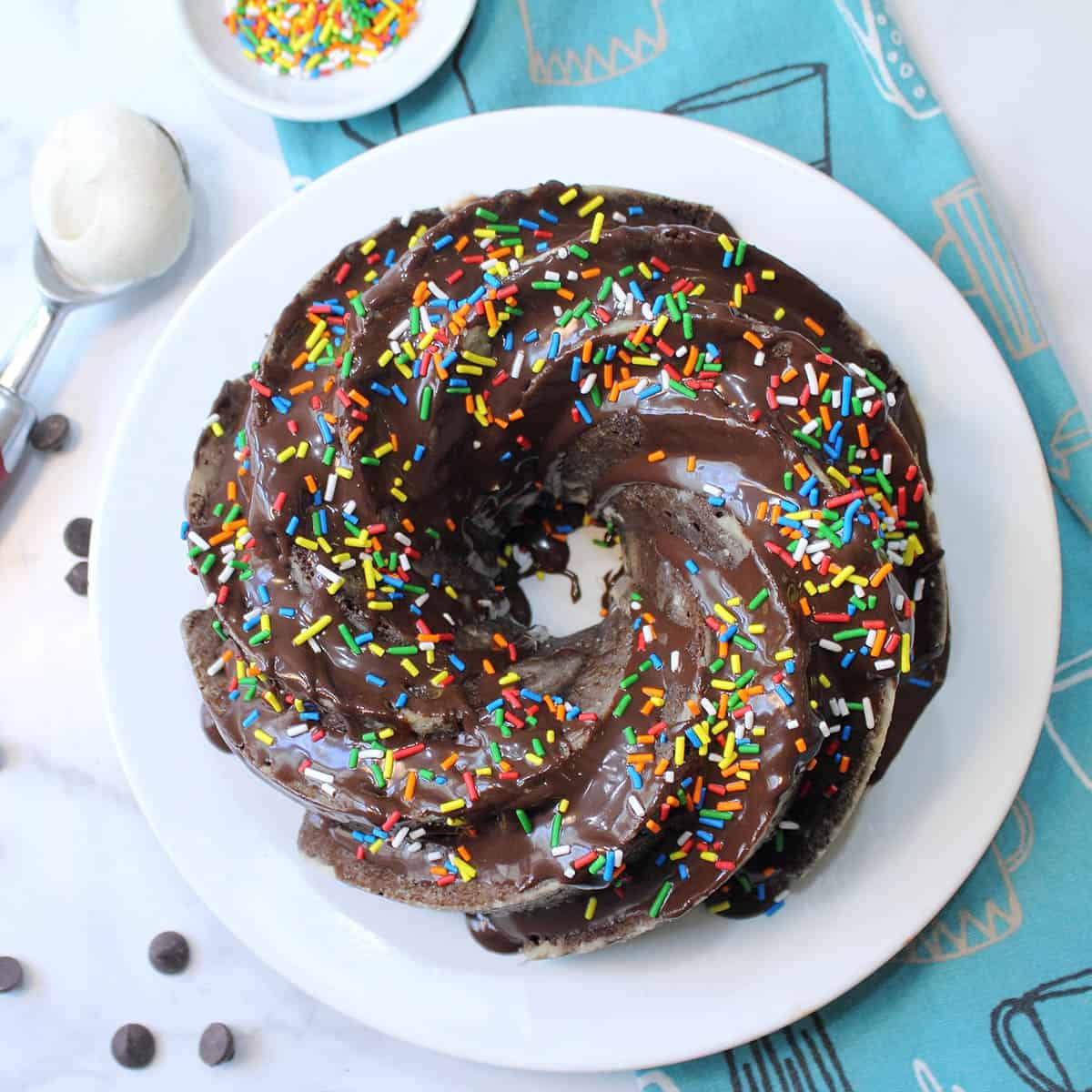 Overhead of finished cake with sprinkles and scoop of ice cream beside it.