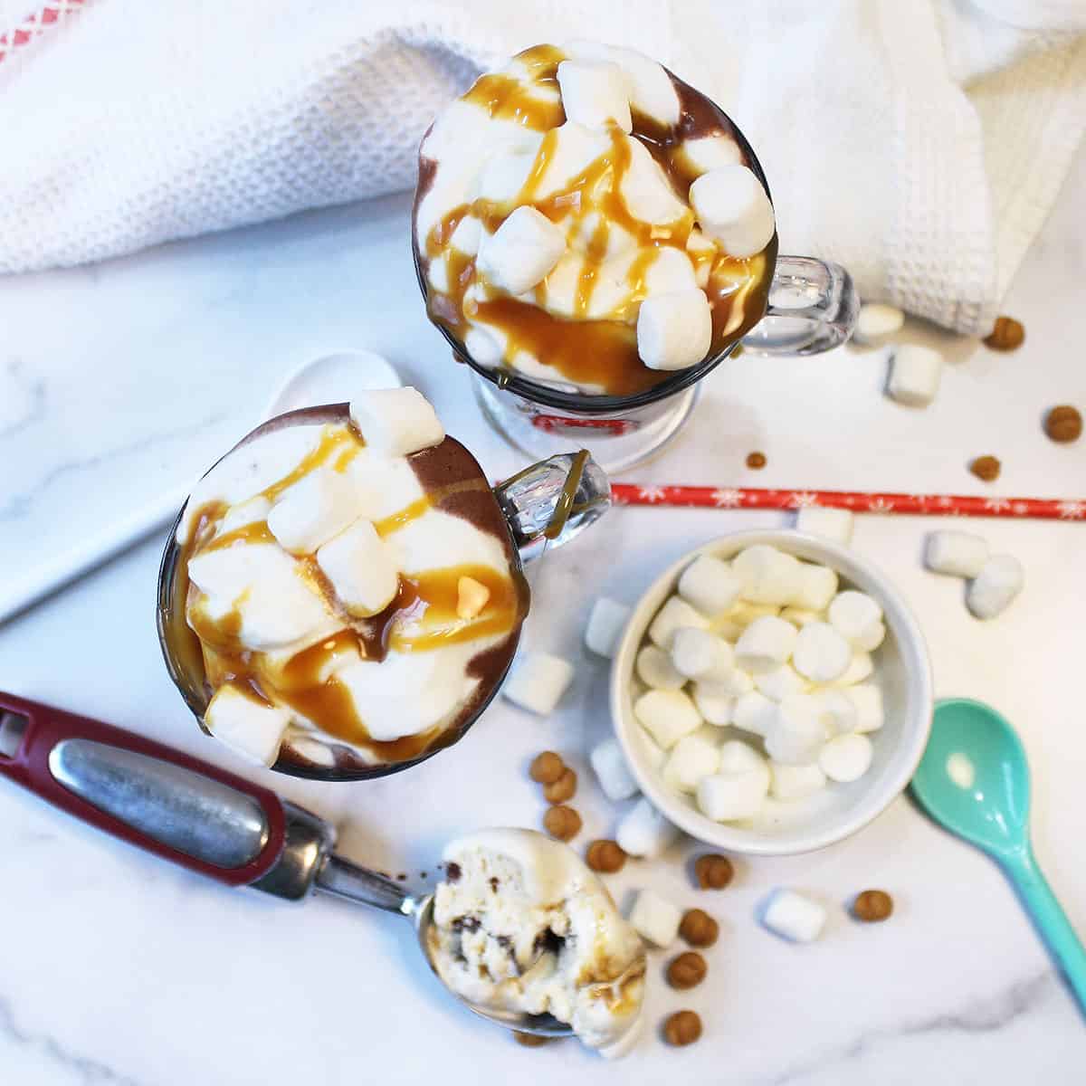Overhead of hot chocolate with whipped cream, marshmallows and caramel sauce.