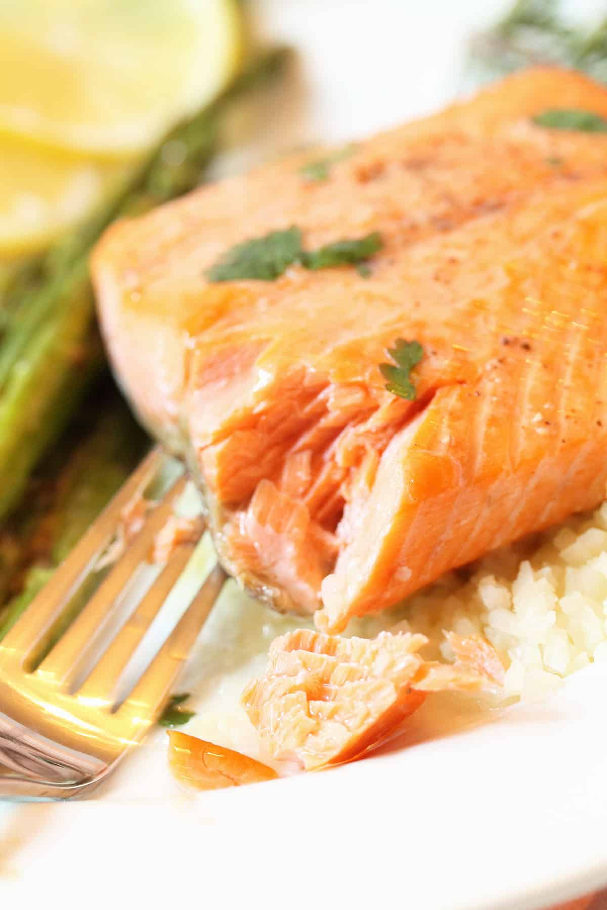 Closeup of salmon with lemon butter sauce showing flakiness.