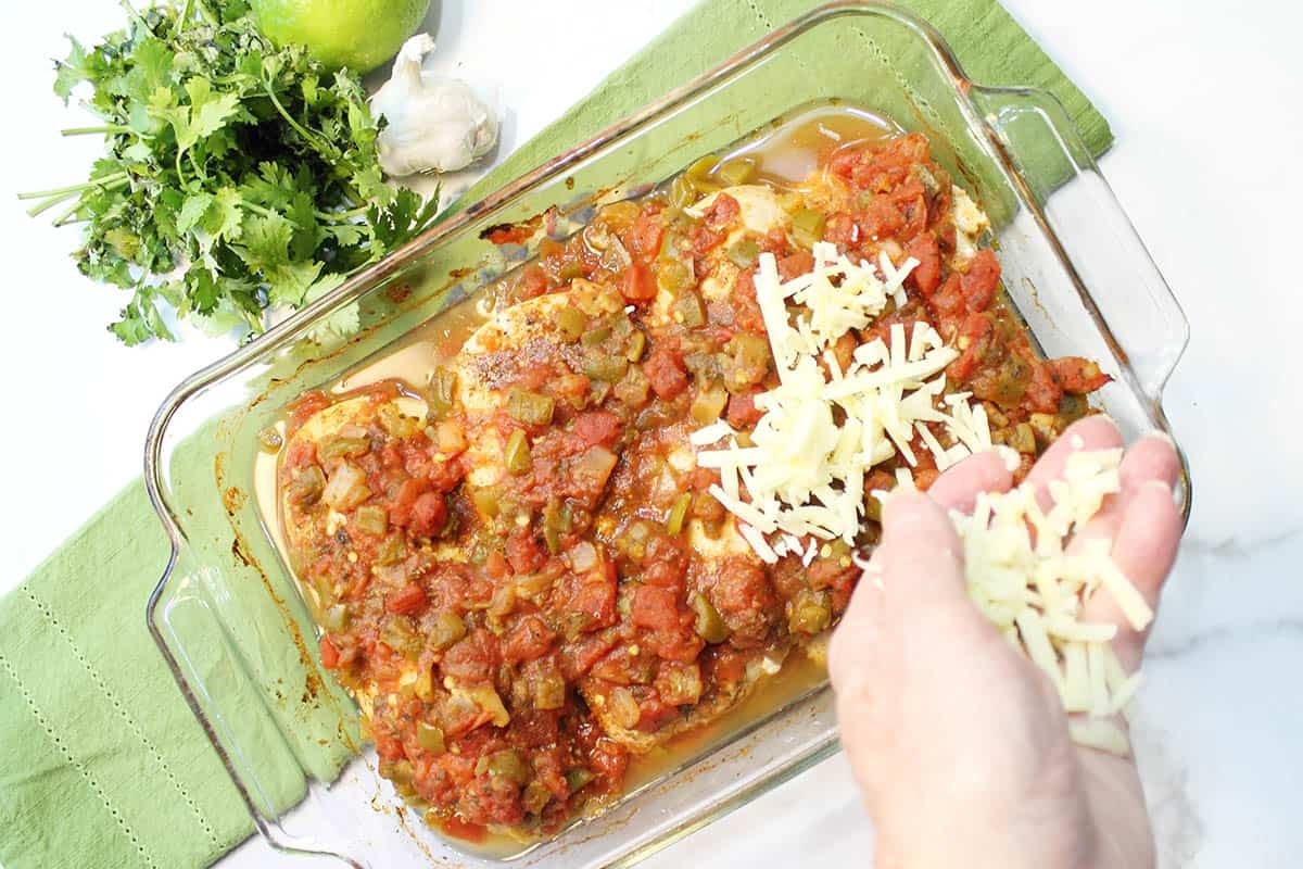 Topping chicken with cheese.