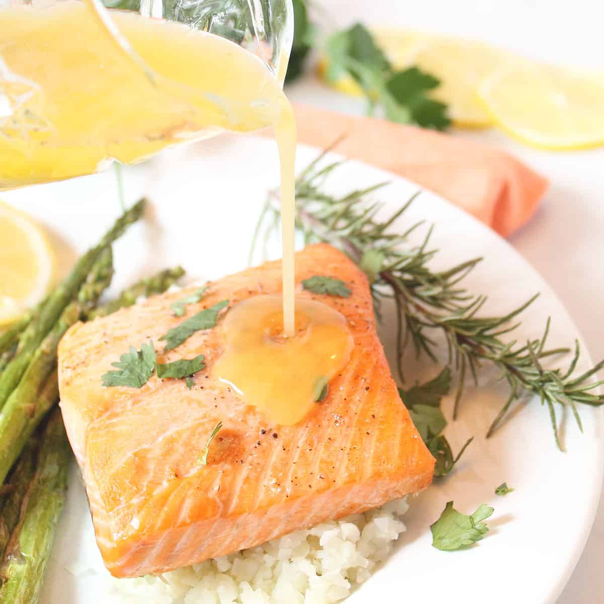 Drizzling butter sauce over air fryer salmon.