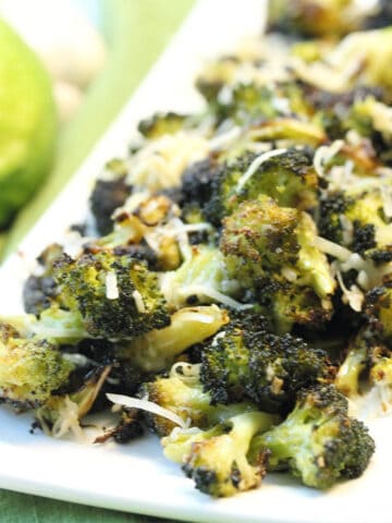 Platter of roasted broccoli with parmesan sprinkled over it.