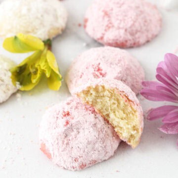 Pink pastel cookie halved on table.