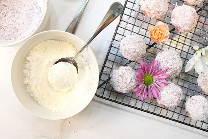 Coating cookies with pastel sugar.