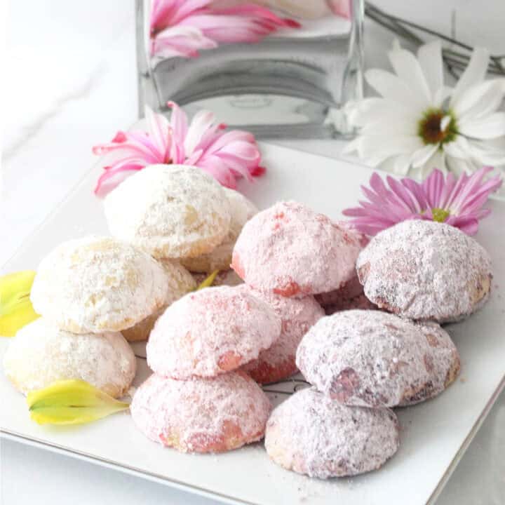 Pastel pink, yellow and purple cookies on serving plate.