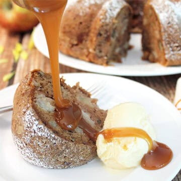 Drizzling caramel sauce over slice of apple bundt cake with scoop of ice cream on side.