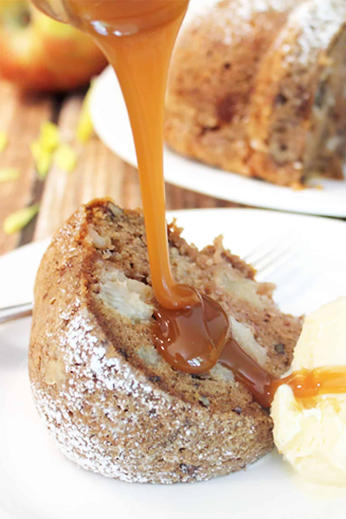 Pouring caramel sauce over slice of fresh apple bundt cake.