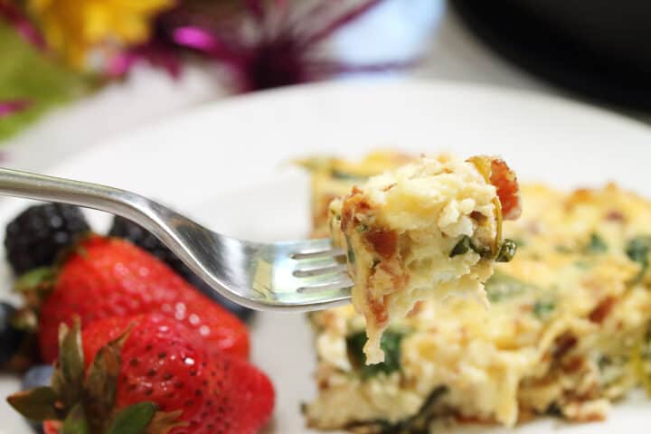 Closeup of bite on fork over plate.