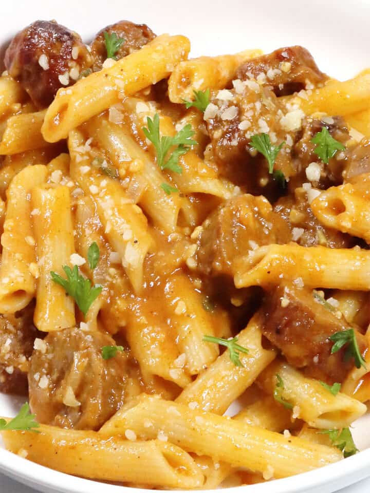 Closeup of creamy pasta and sausage in serving bowl.