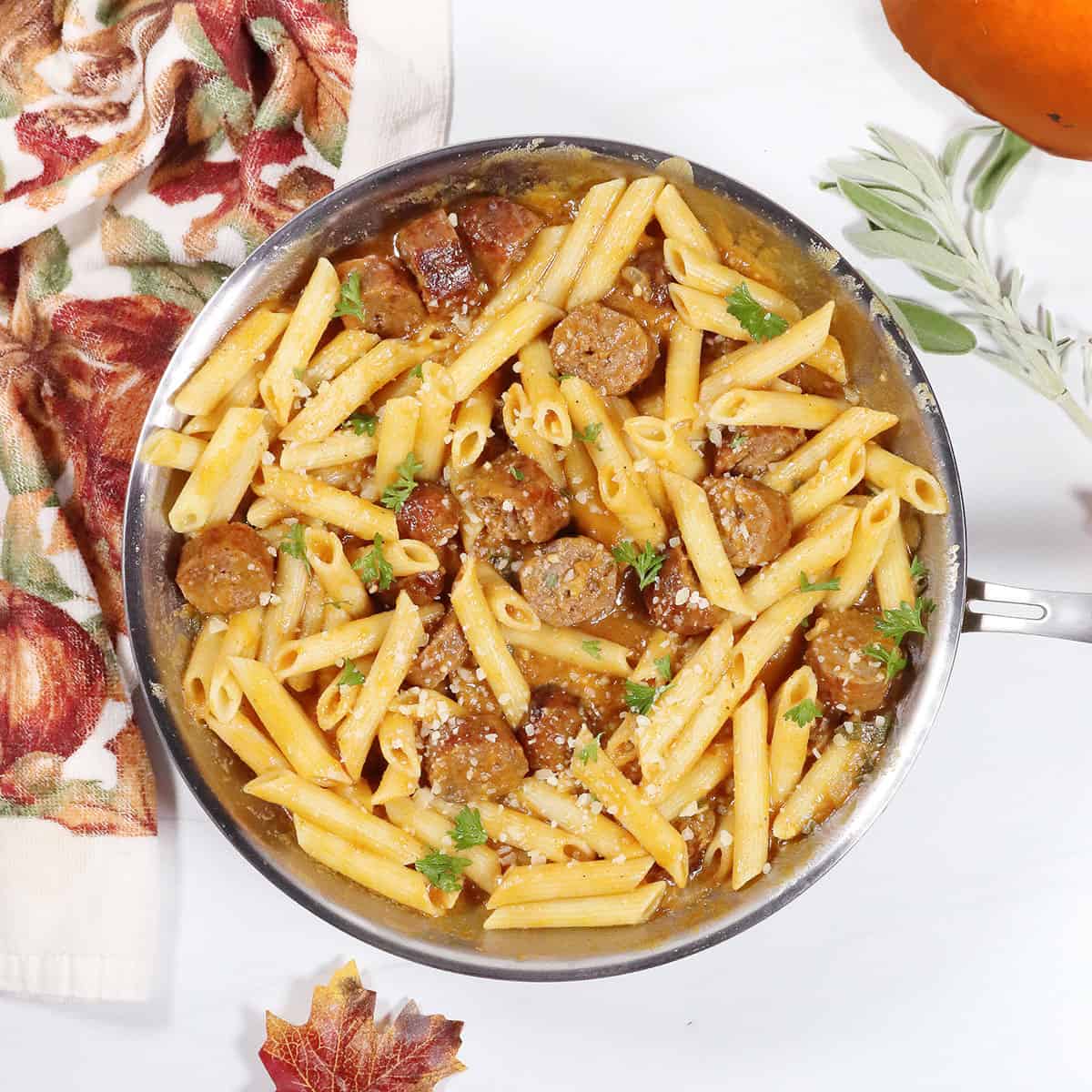 Creamy Sausage Pasta with Pumpkin Sauce garnished in skillet.