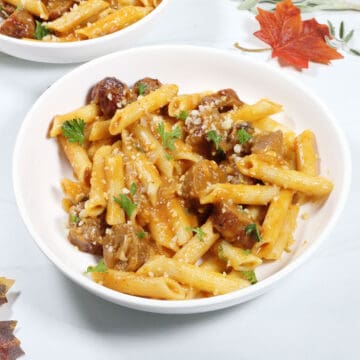 Bowlful of sausage and pasta with pumpkin sauce.