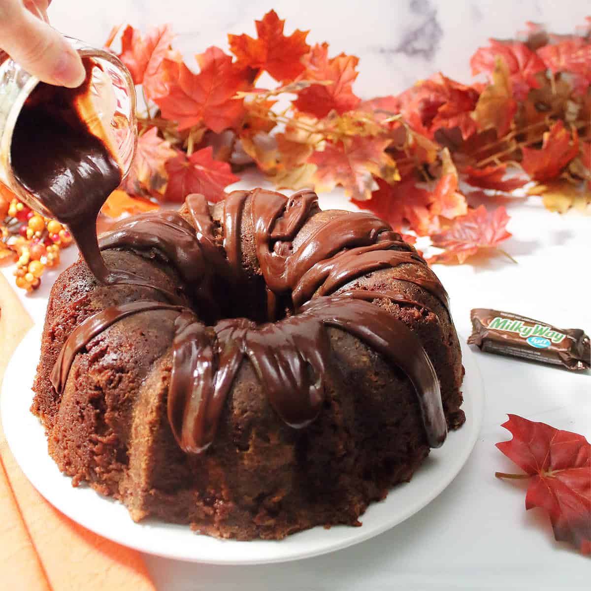 Pouring chocolate glaze over cake.