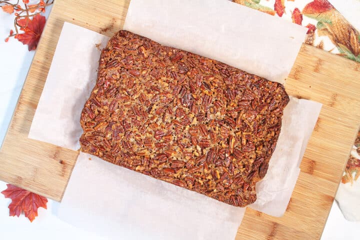 Pecan bars on cutting board.