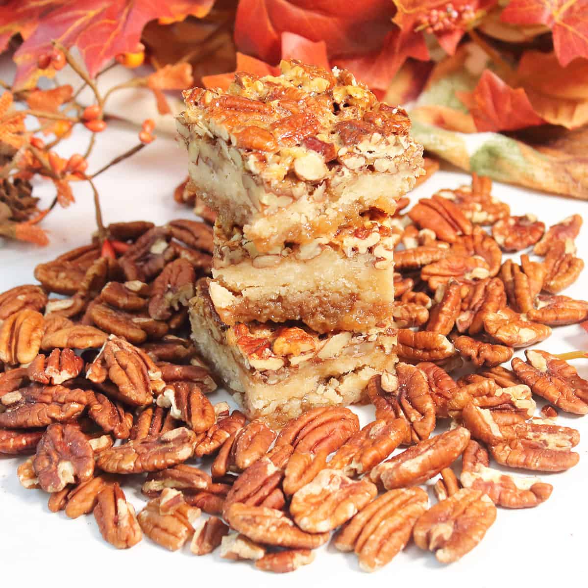 Stack of bars amidst pecans with fall leaves in back.