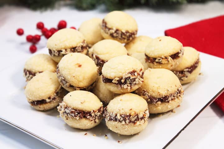 Almond Shortbread Cookies piled on white Christmas platter.