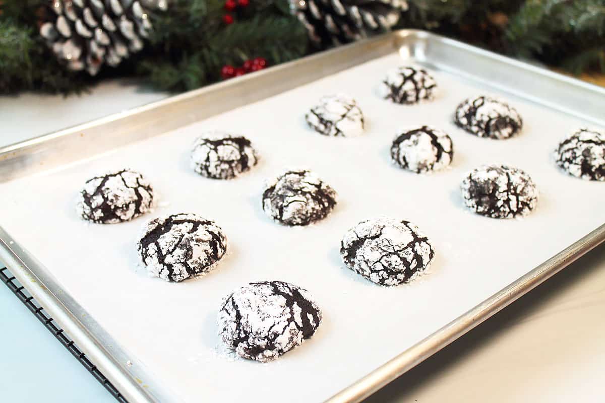 Baked crinkle cookies on cookie sheet.