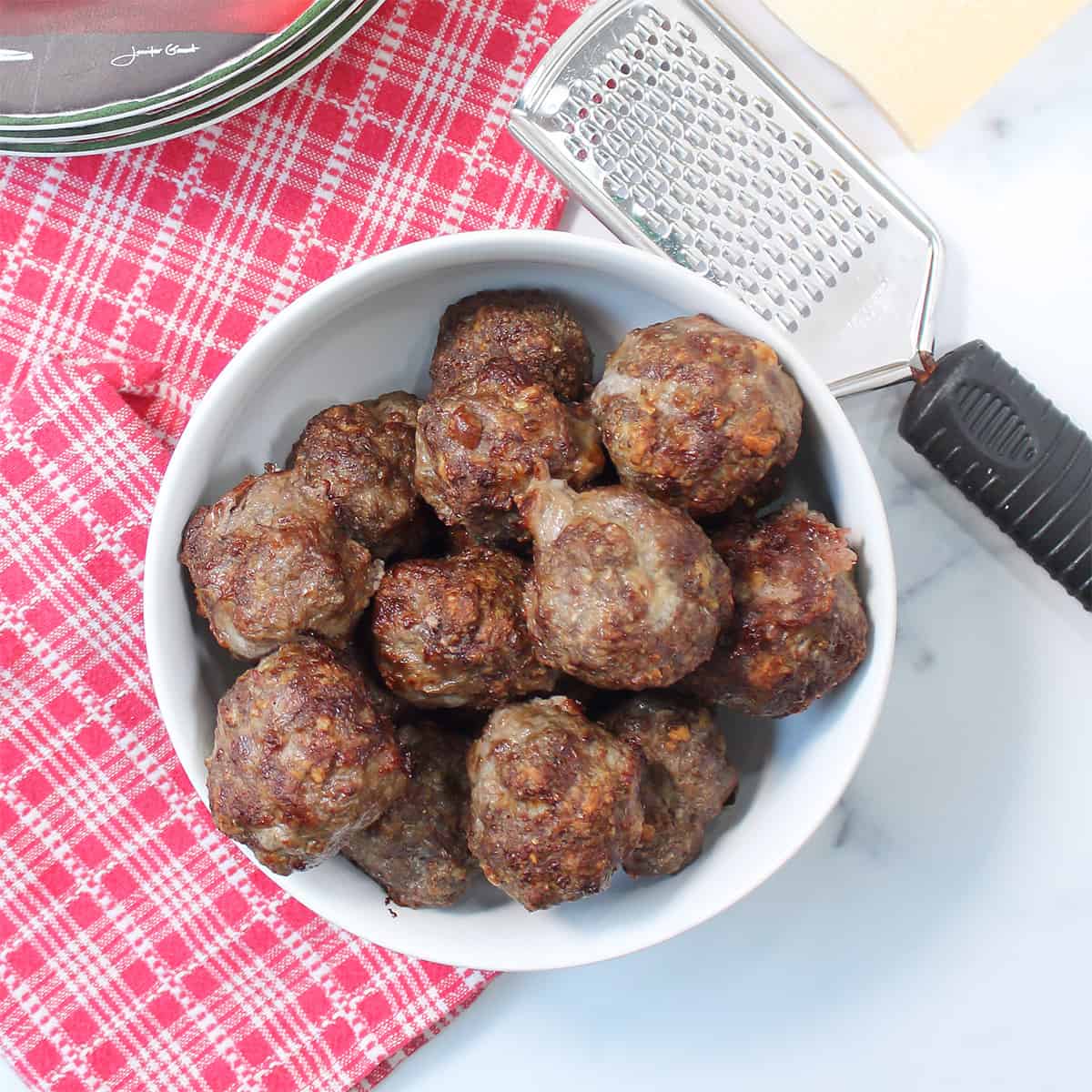 Overhead of air fried meatballs in white bowl.