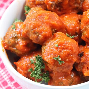 Closeup view of meatballs with red sauce.