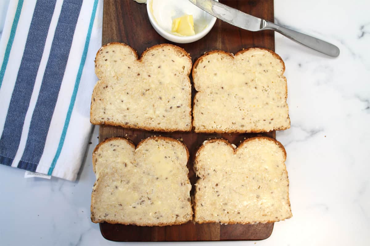 Buttered bread on wooden board.