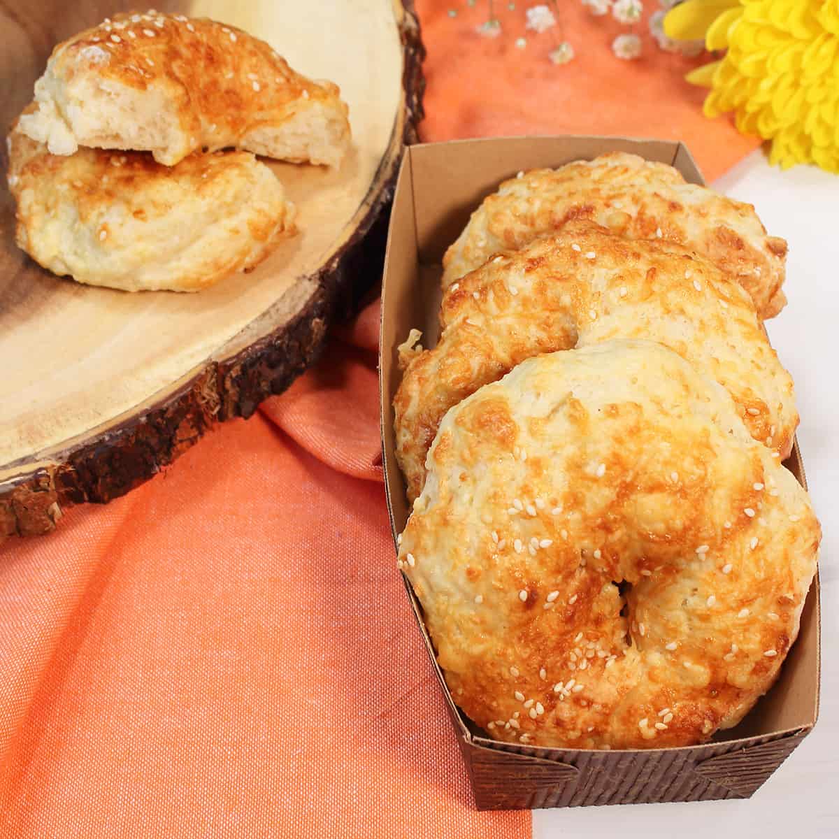 Golden asiago bagels in basket with one cut open.