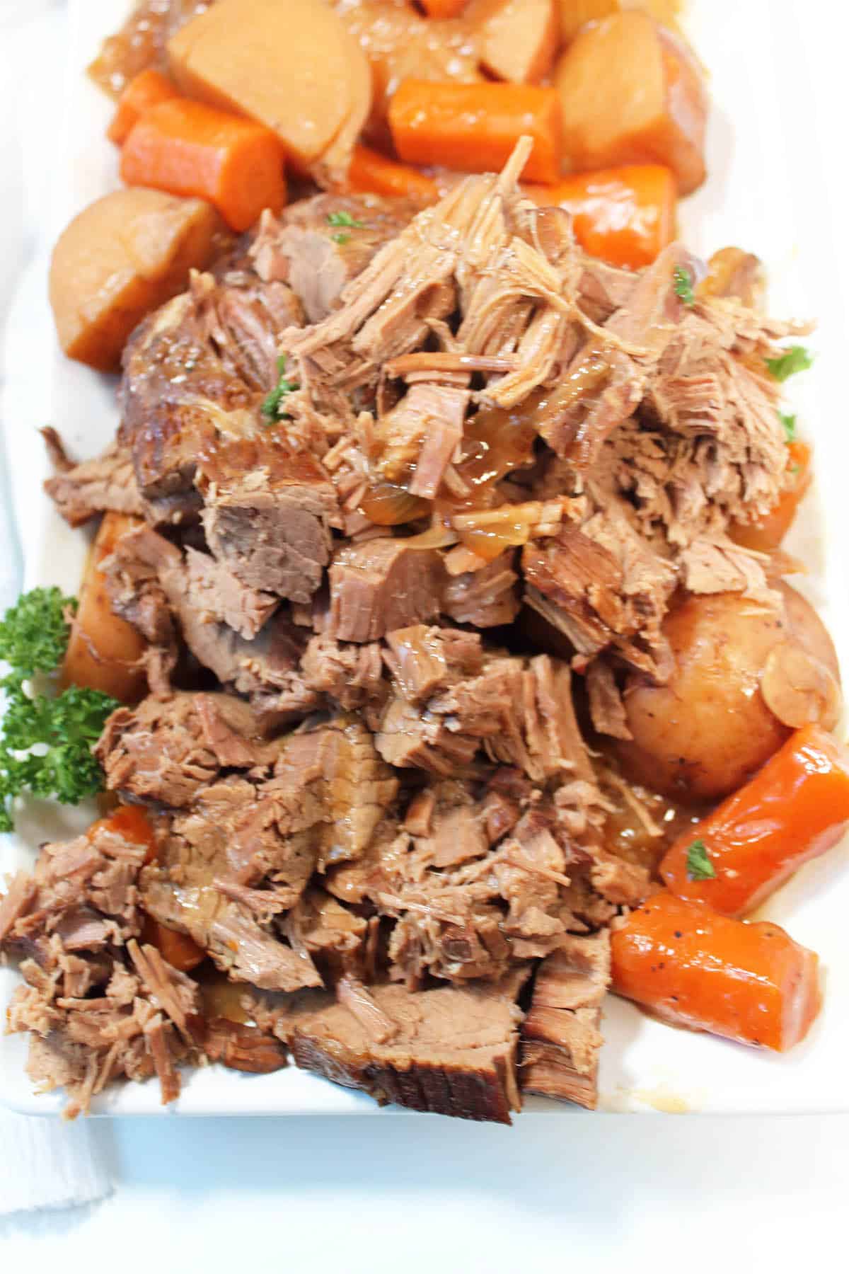 Showing tender fall-apart crockpot eye of round roast on platter.