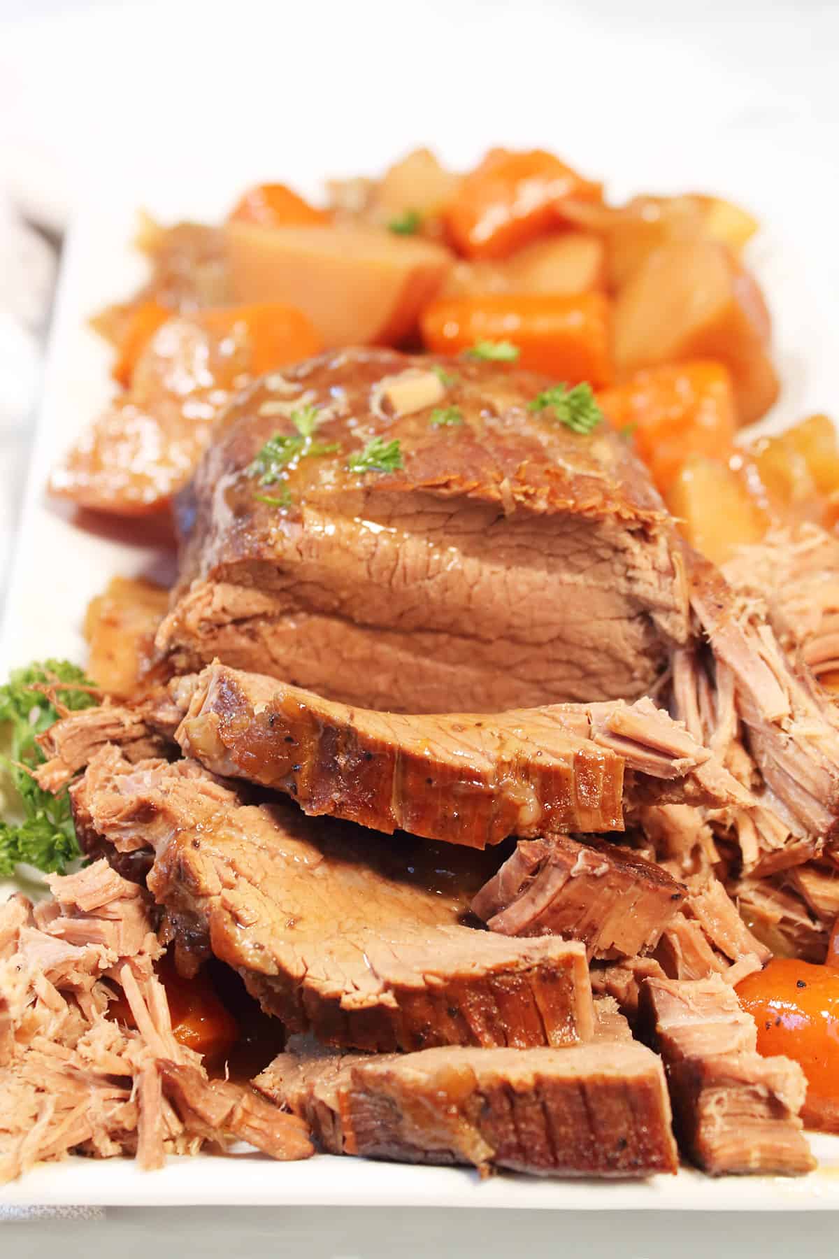 Sliced slow cooker pot roast on platter.