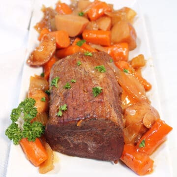 Roast on platter with carrots and potatoes.