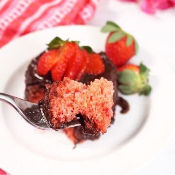 Closeup of bite over ganache covered mug cake.