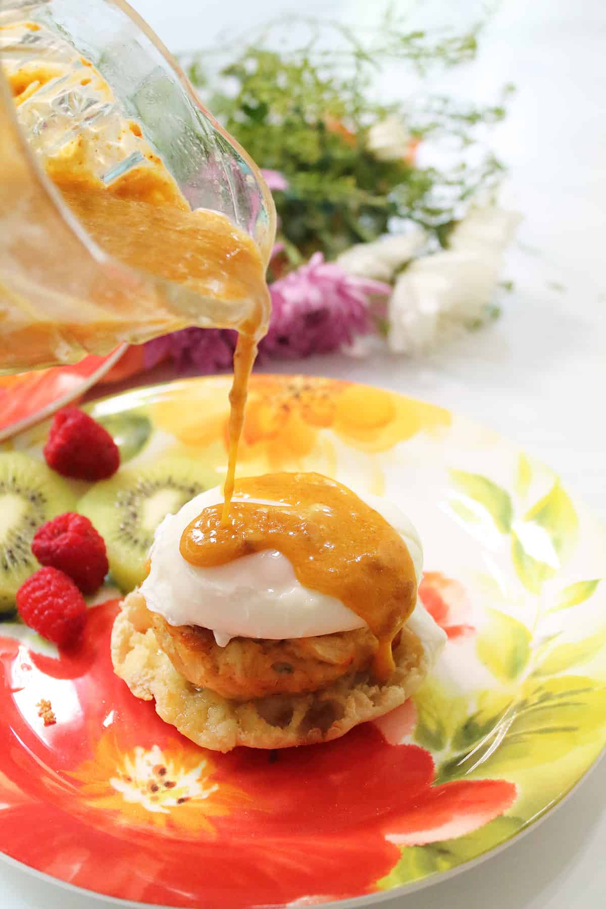 Drizzling blender hollandaise sauce over crab cake benedict.