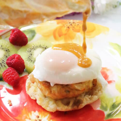 Drizzling Hollandaise sauce over crab cake eggs benedict.