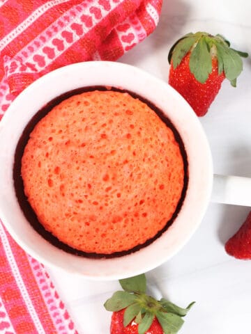 Overhead of strawberry mug cake with strawberries.