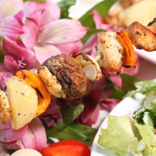 Air fryer chicken skewer surrounded by flowers.