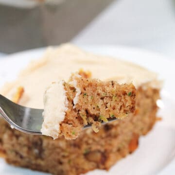 Slice of spiced zucchini cake with bite on fork.